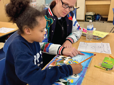 student reading book with teacher